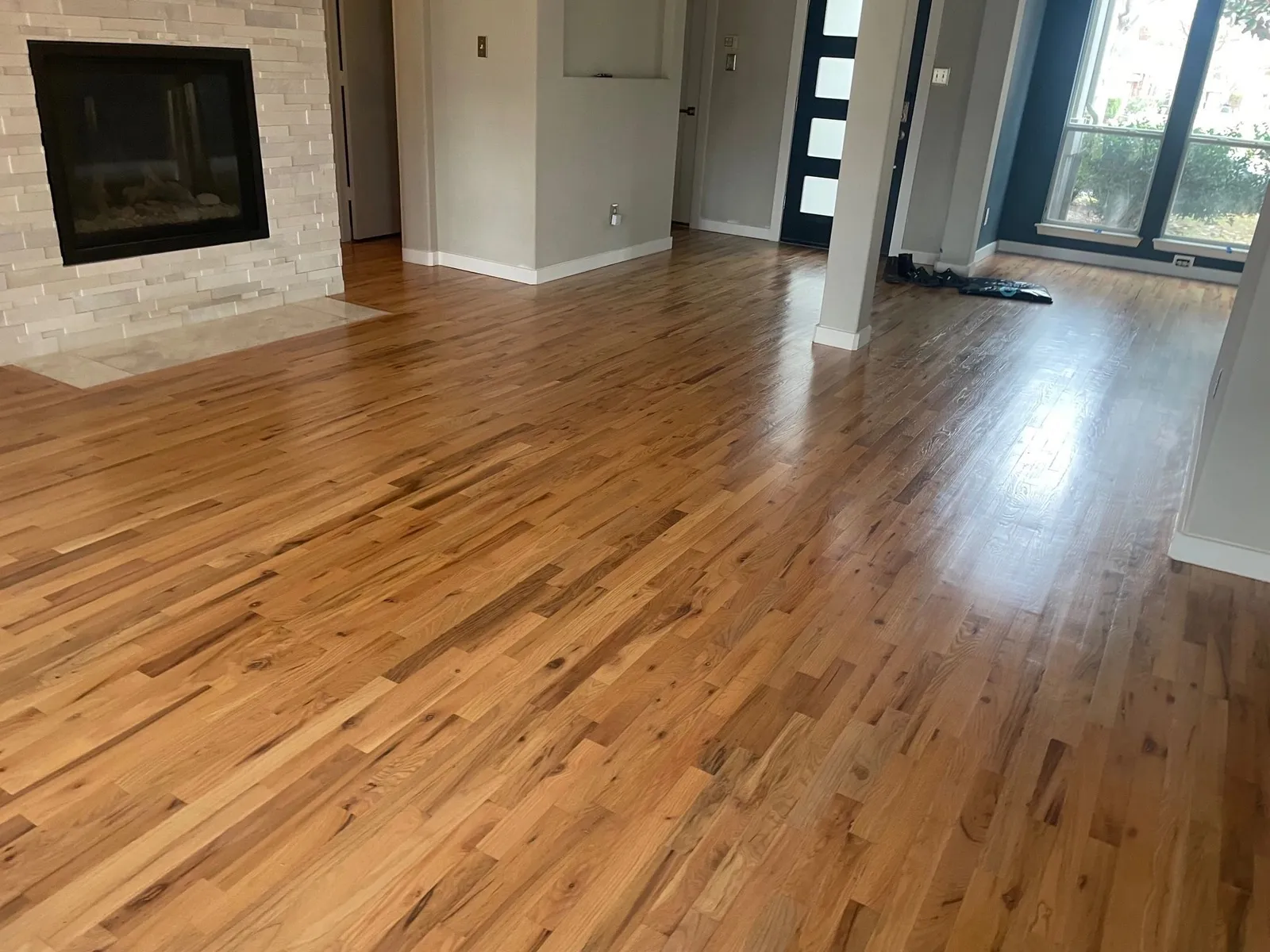 Freshly refinished red oak hardwood flooring running through a great room and entry in a McKinney, TX home