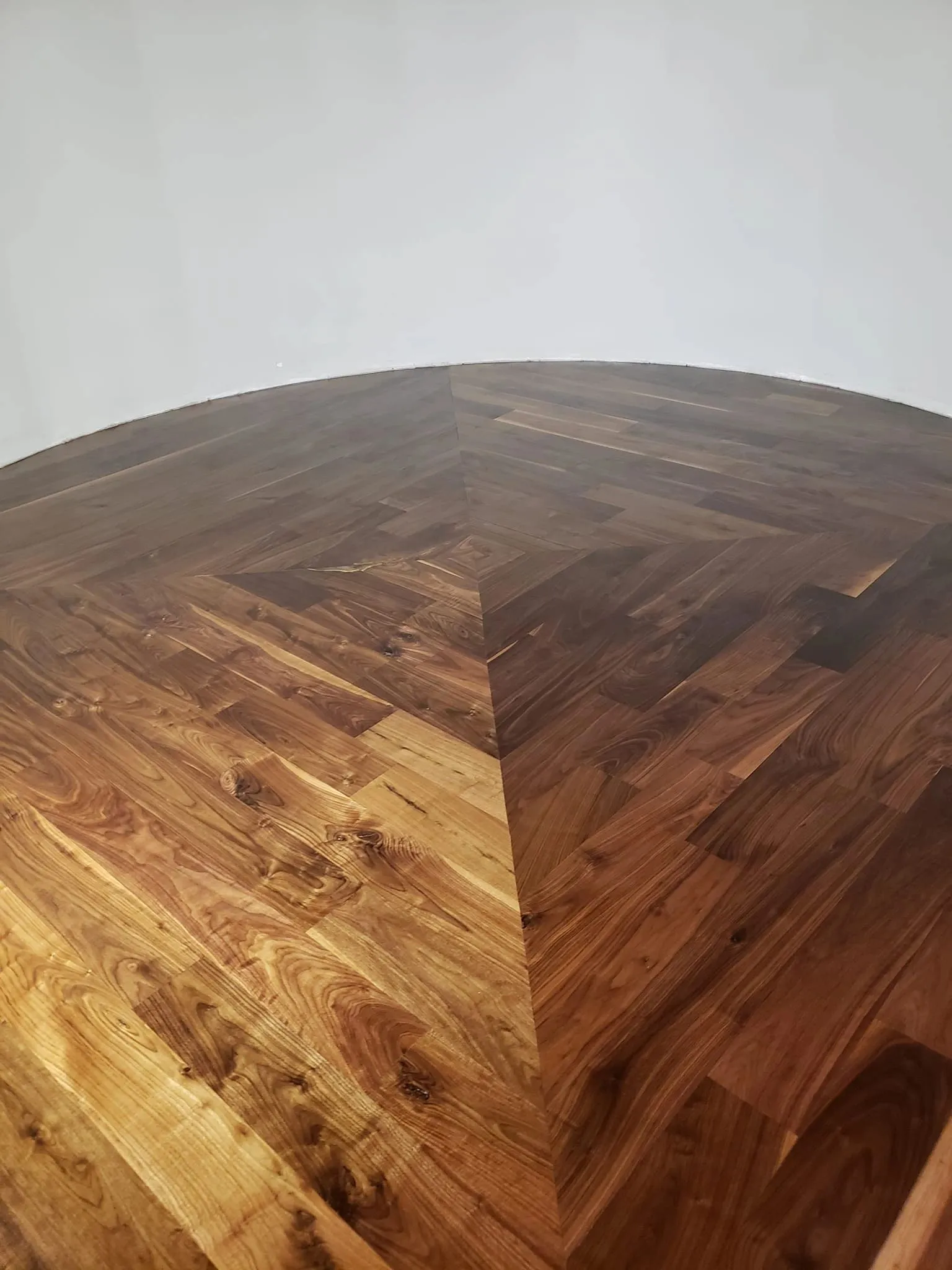 Custom walnut chevron hardwood flooring installed in a curved room by Artistry Floors, McKinney TX